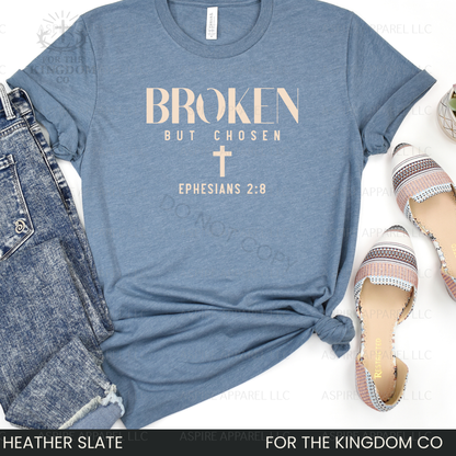 Heather slate blue t-shirt with 'Broken But Chosen' text and cross, paired with jeans and sandals on a white background.